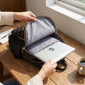 Black travel laptop backpack with laptop on desk